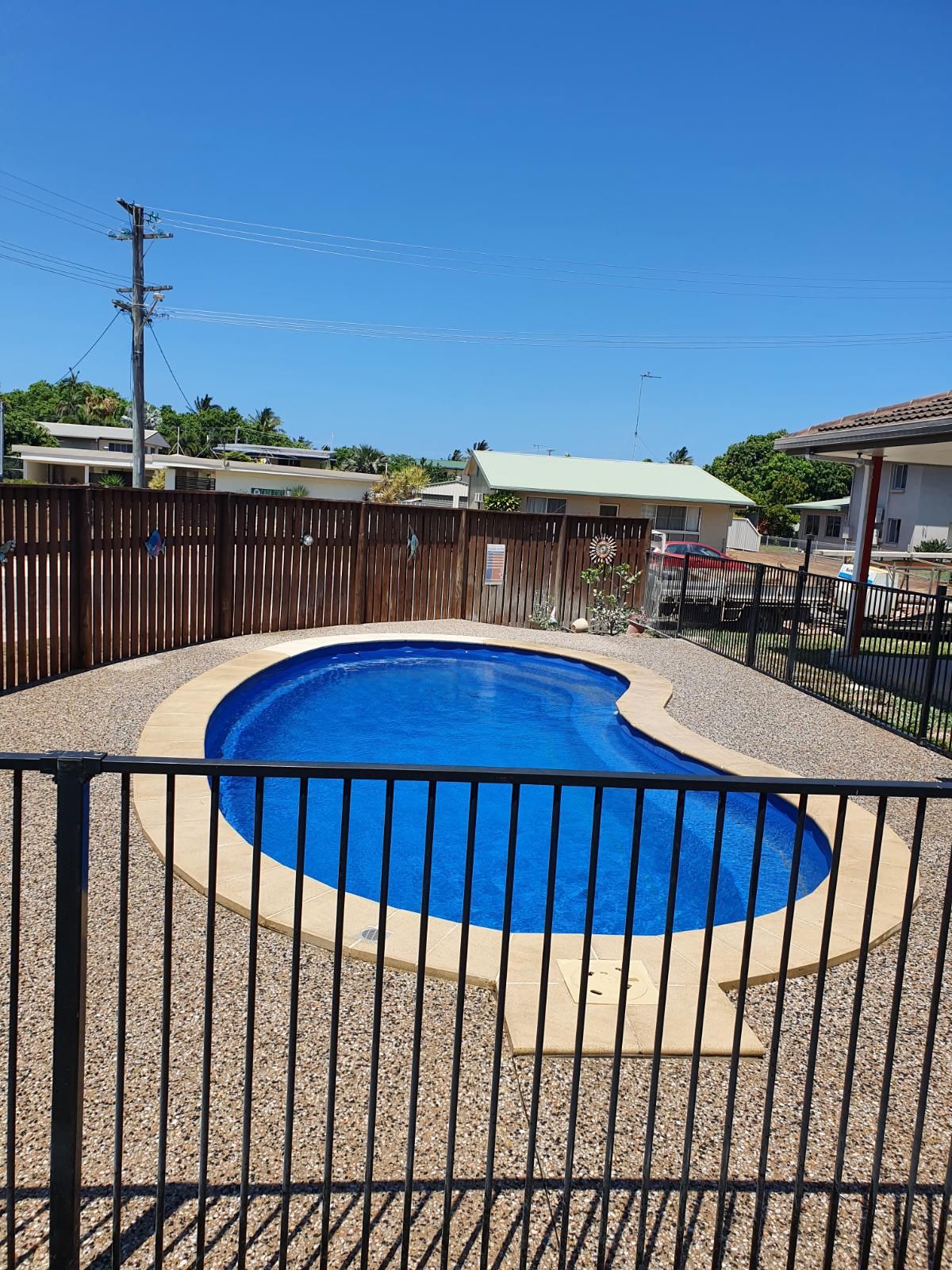 A Patio With Tiles and a Pool in the Background — Bark Concreting In Ryan, QLD