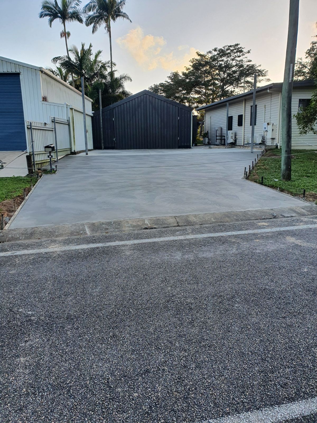 A Concrete Driveway Leading to a Garage in a Field — Bark Concreting In Ryan, QLD