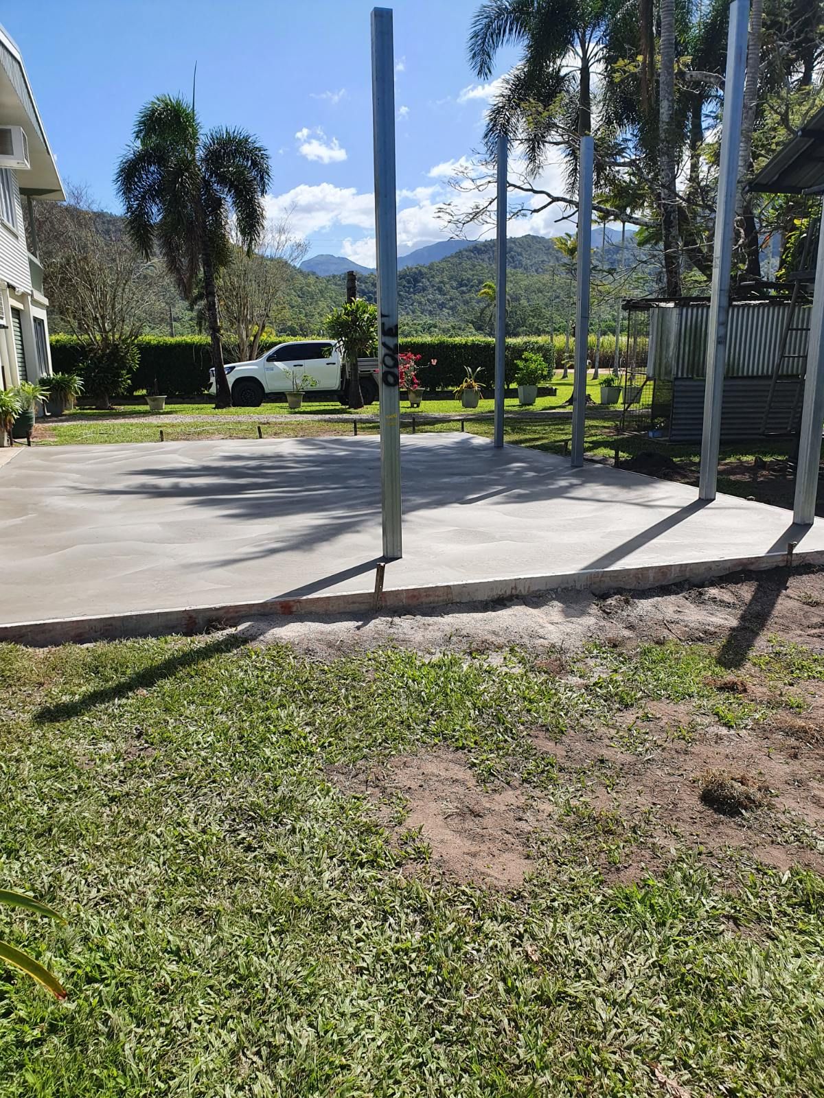 A Large Concrete Slab is Sitting in Front of a House Under Construction — Bark Concreting In Ryan, QLD