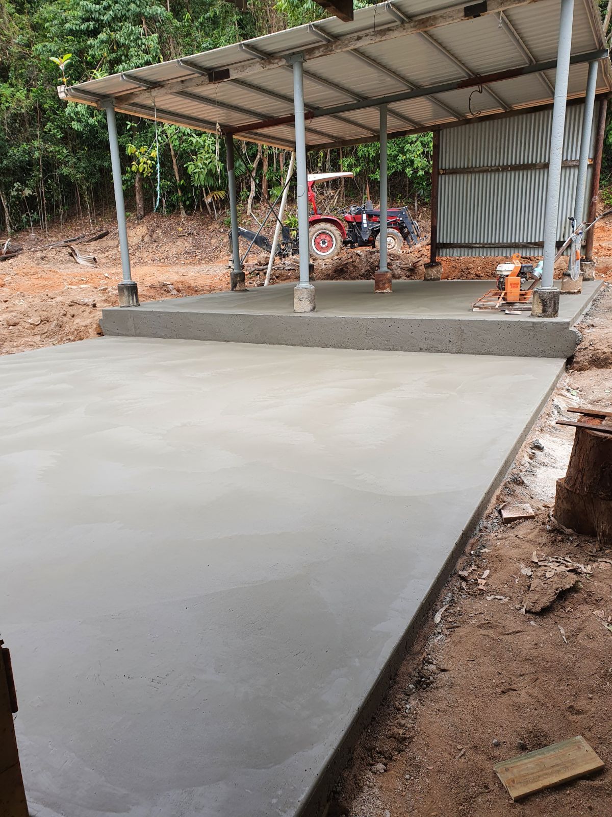 A Yellow Bulldozer is Working on a Dirt Field — Bark Concreting In Ryan, QLD