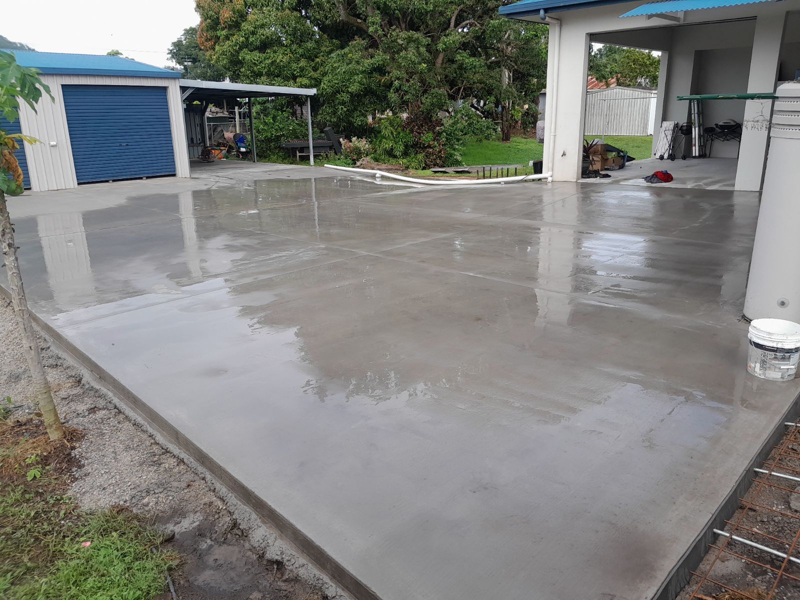 A Concrete Driveway Is Being Built In Front Of A Garage — Bark Concreting In Ryan, QLD