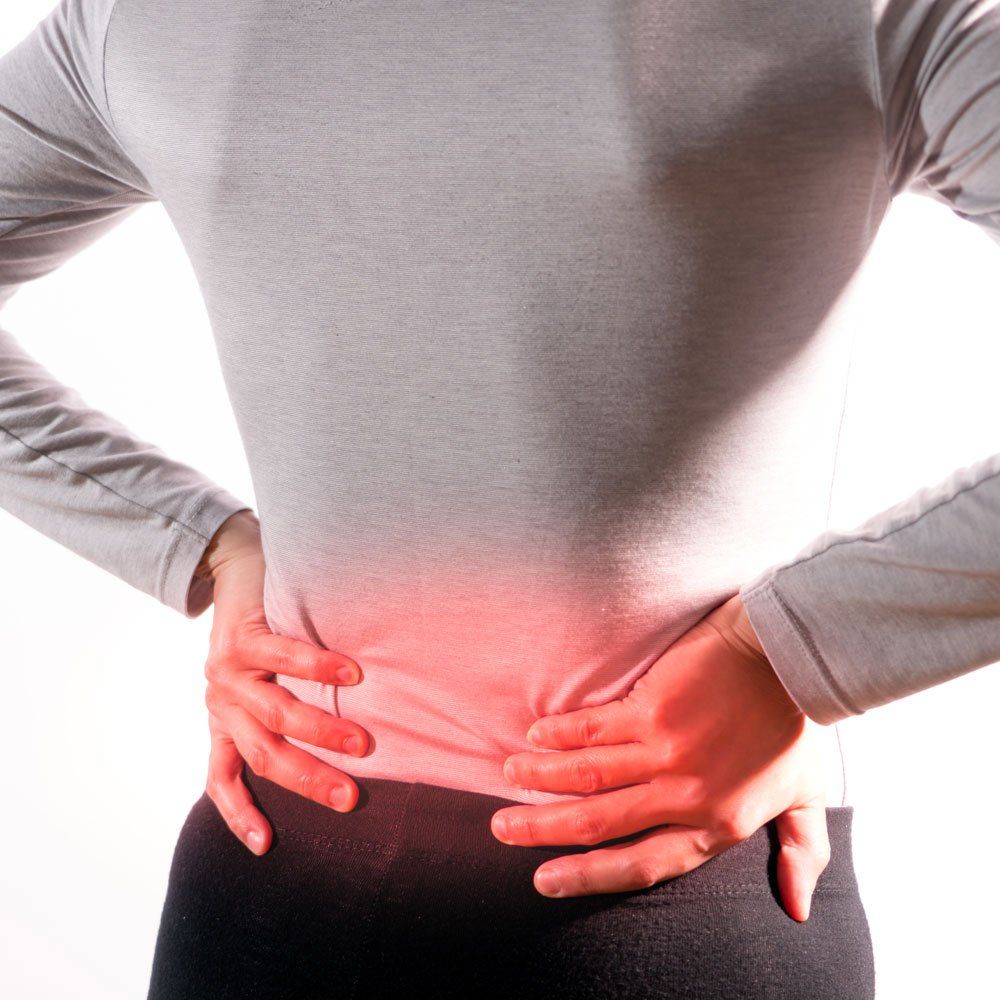Person holding lower back, red highlighted pain area on the waist.