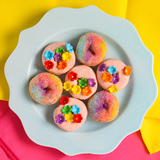 strawberry shortcake mini donuts with groovy flowers and sprinkles on a blue plate