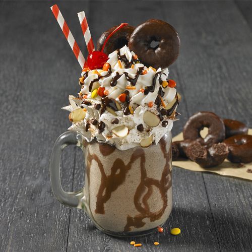 fudge round milkshake topped with whipped cream, candy and a cherry