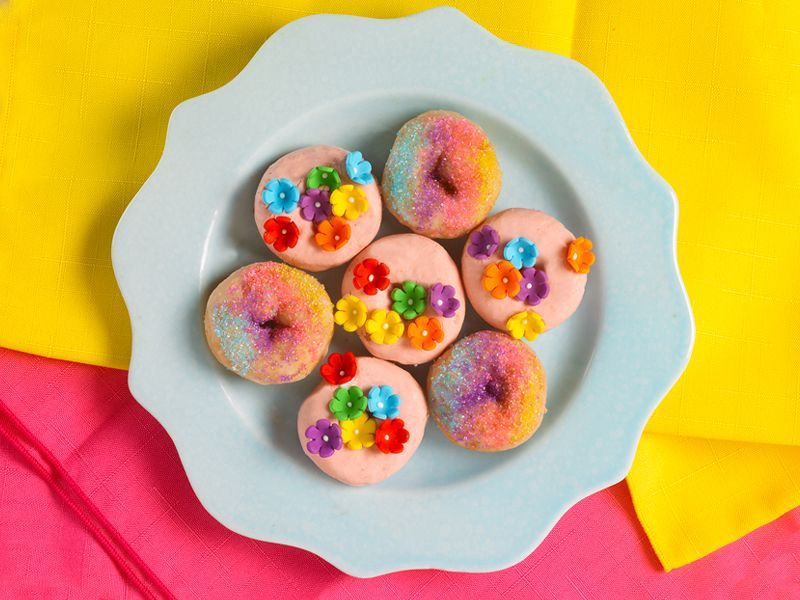 strawberry shortcake mini donuts with groovy flowers and sprinkles on a blue plate