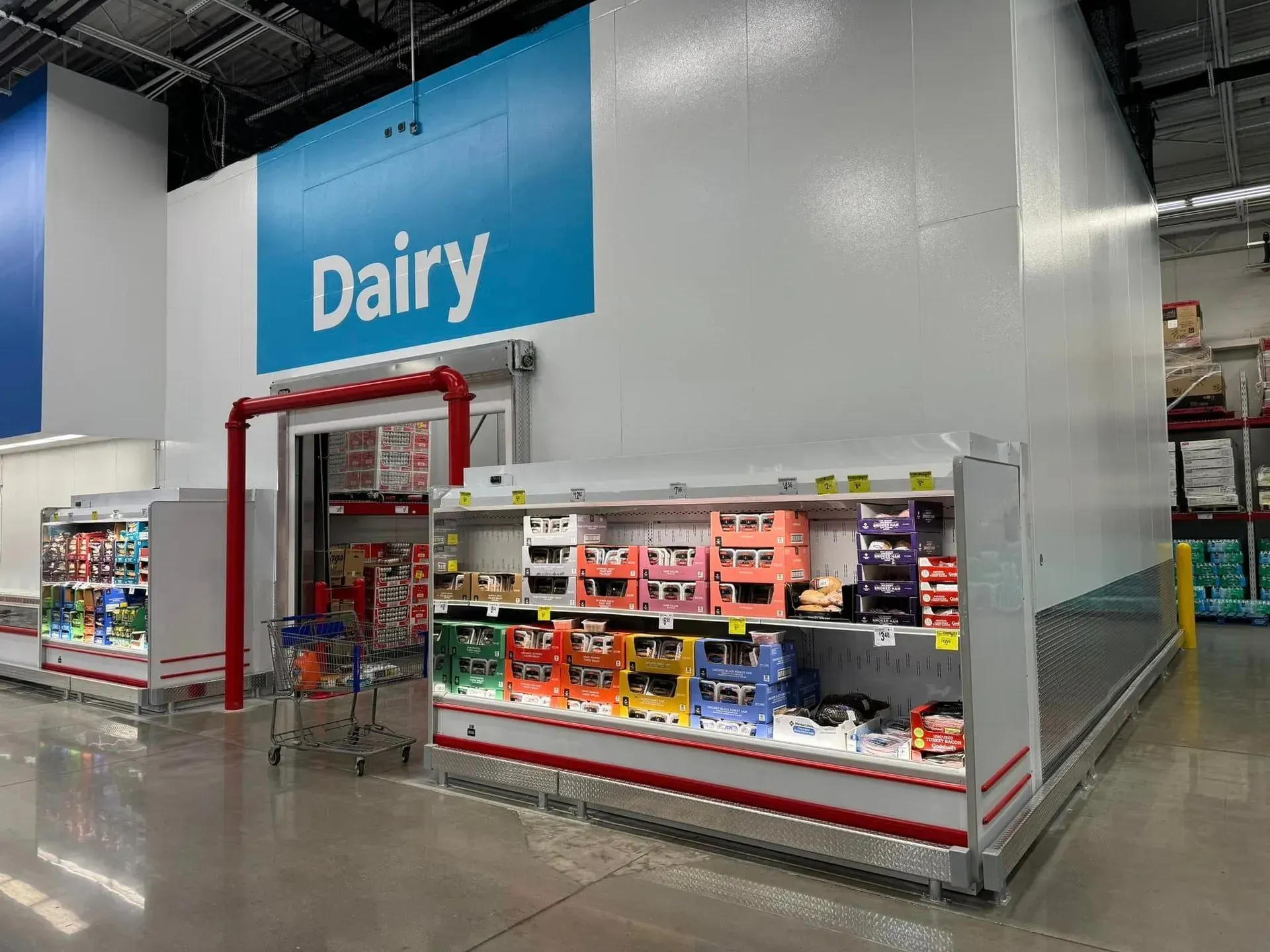 A dairy section of a grocery store with a blue sign above it.