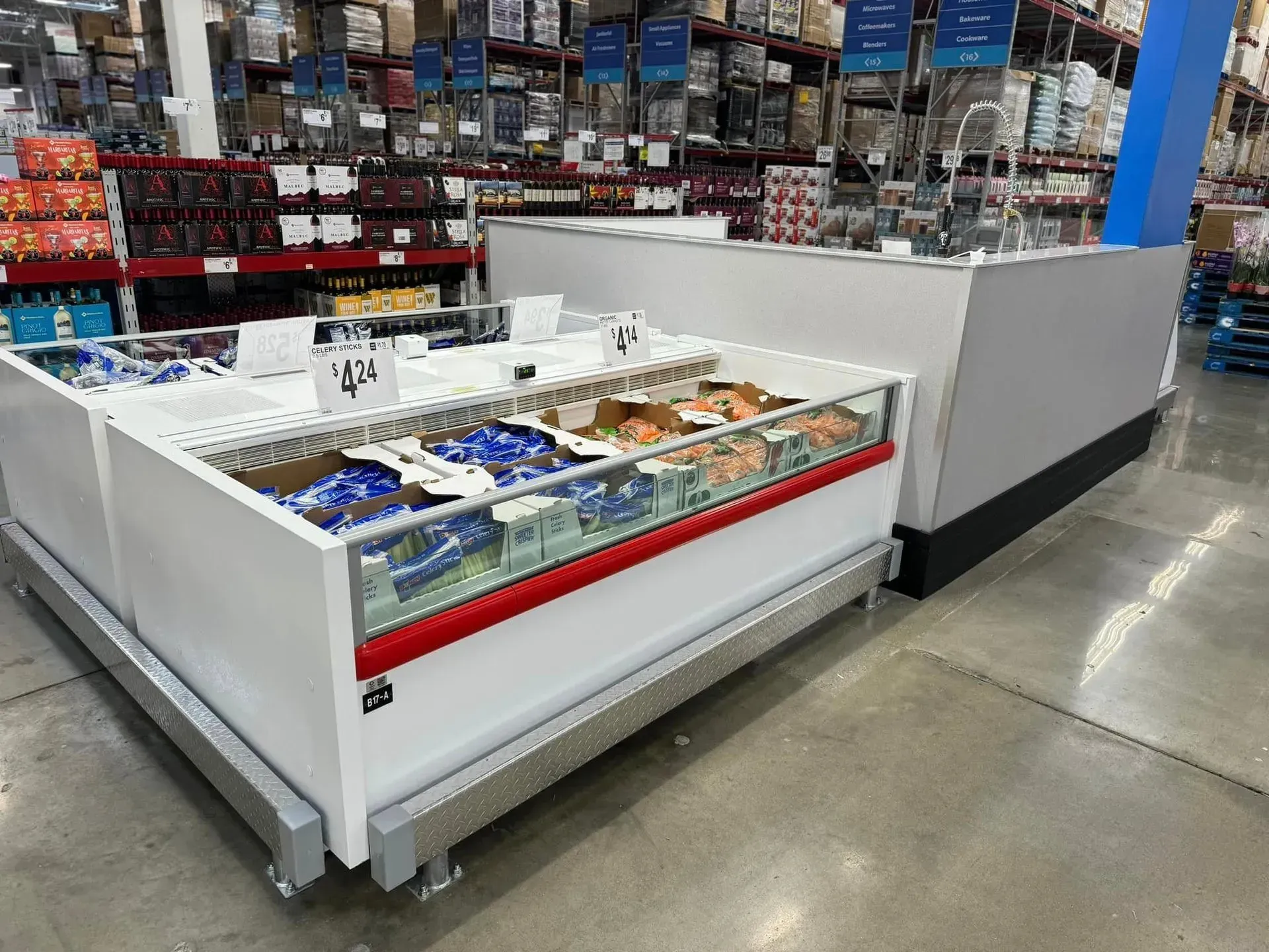 A frozen display case in a store with a lot of food in it.