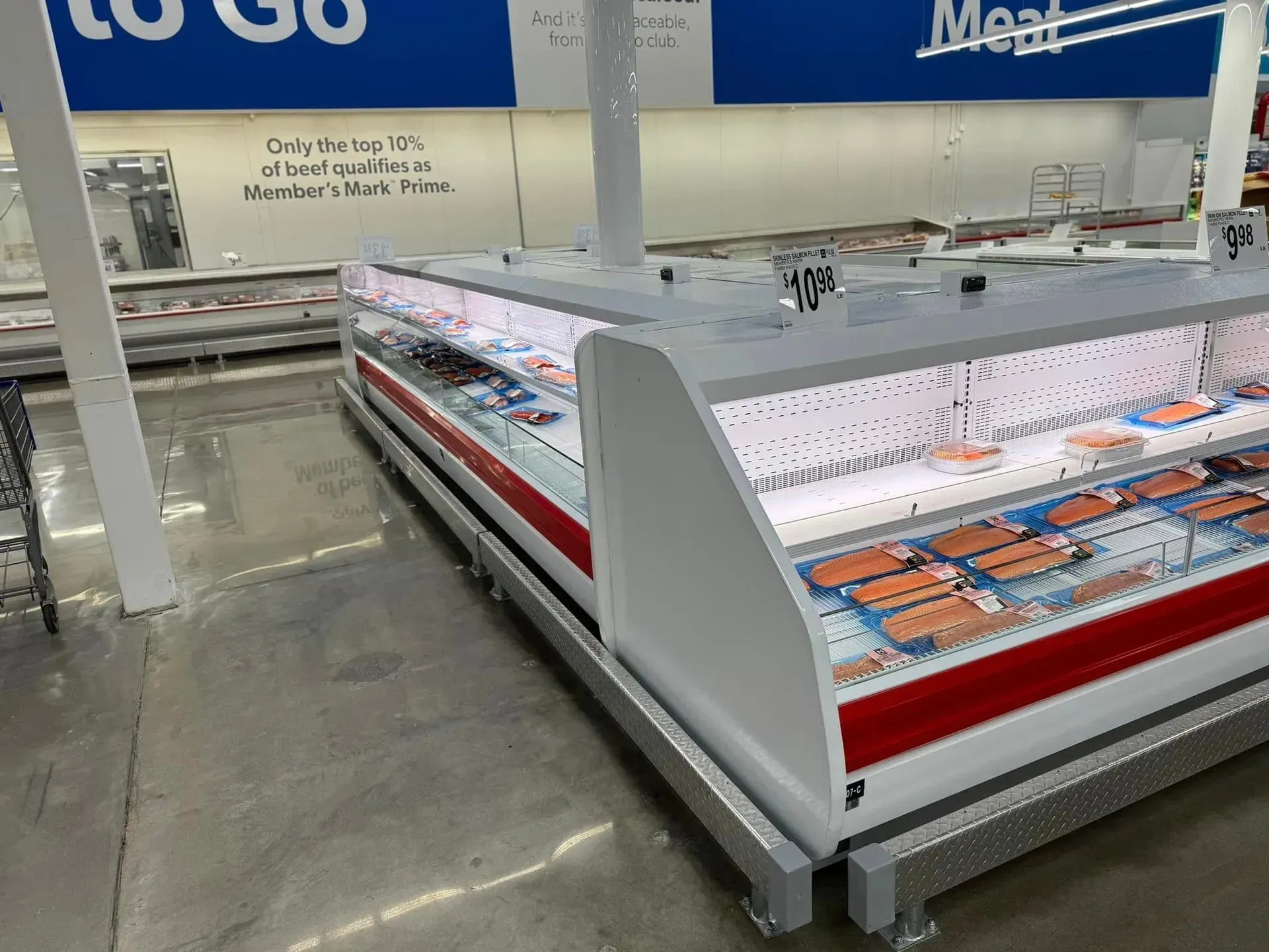 A refrigerated display case in a grocery store filled with meat.