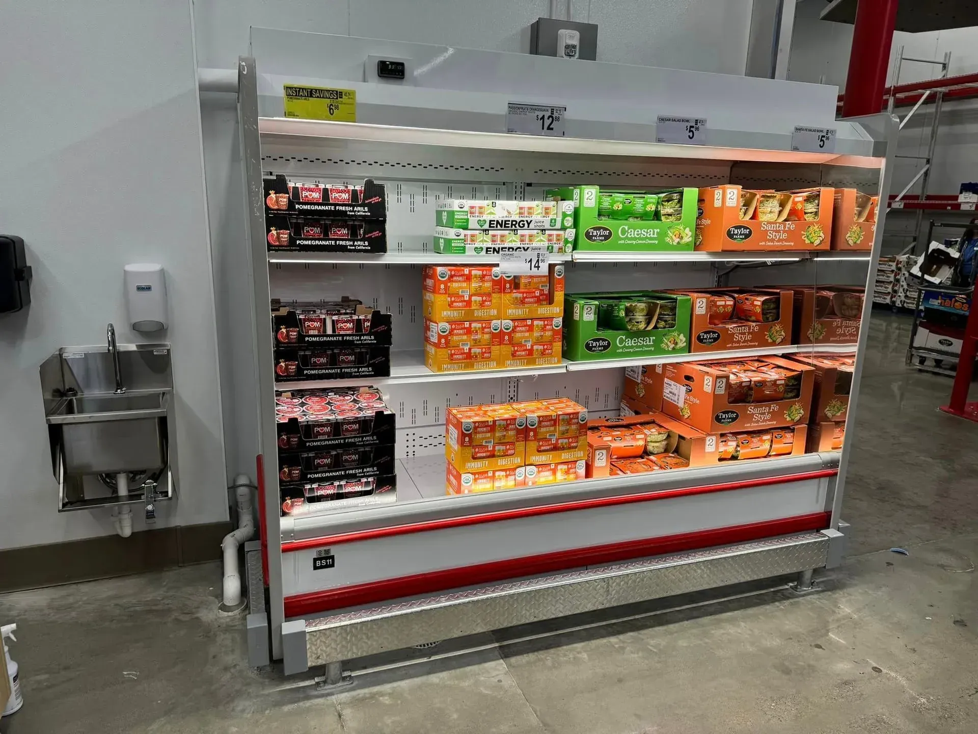A refrigerator filled with lots of food in a store.