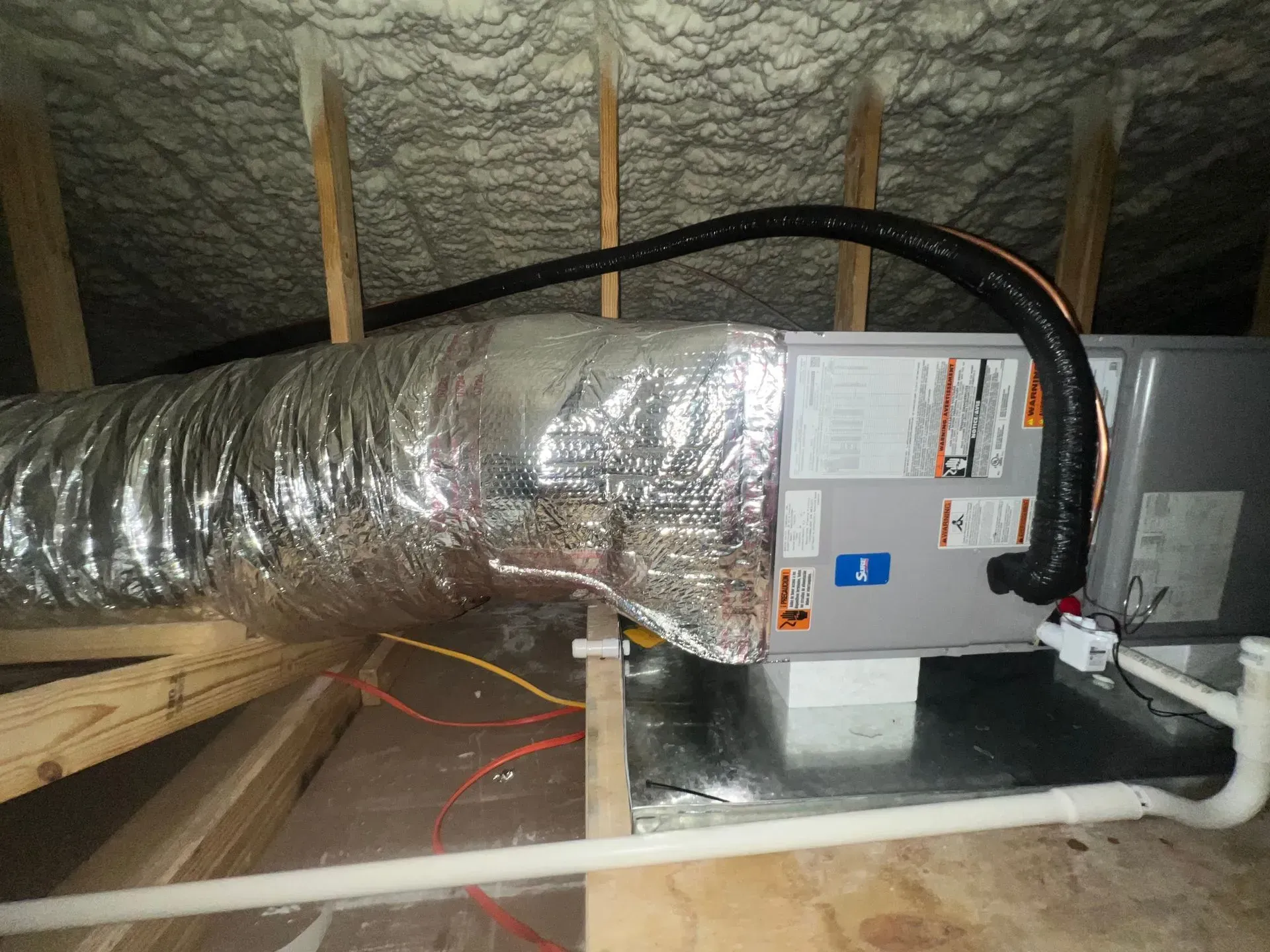 An air conditioner is installed in the attic of a house.