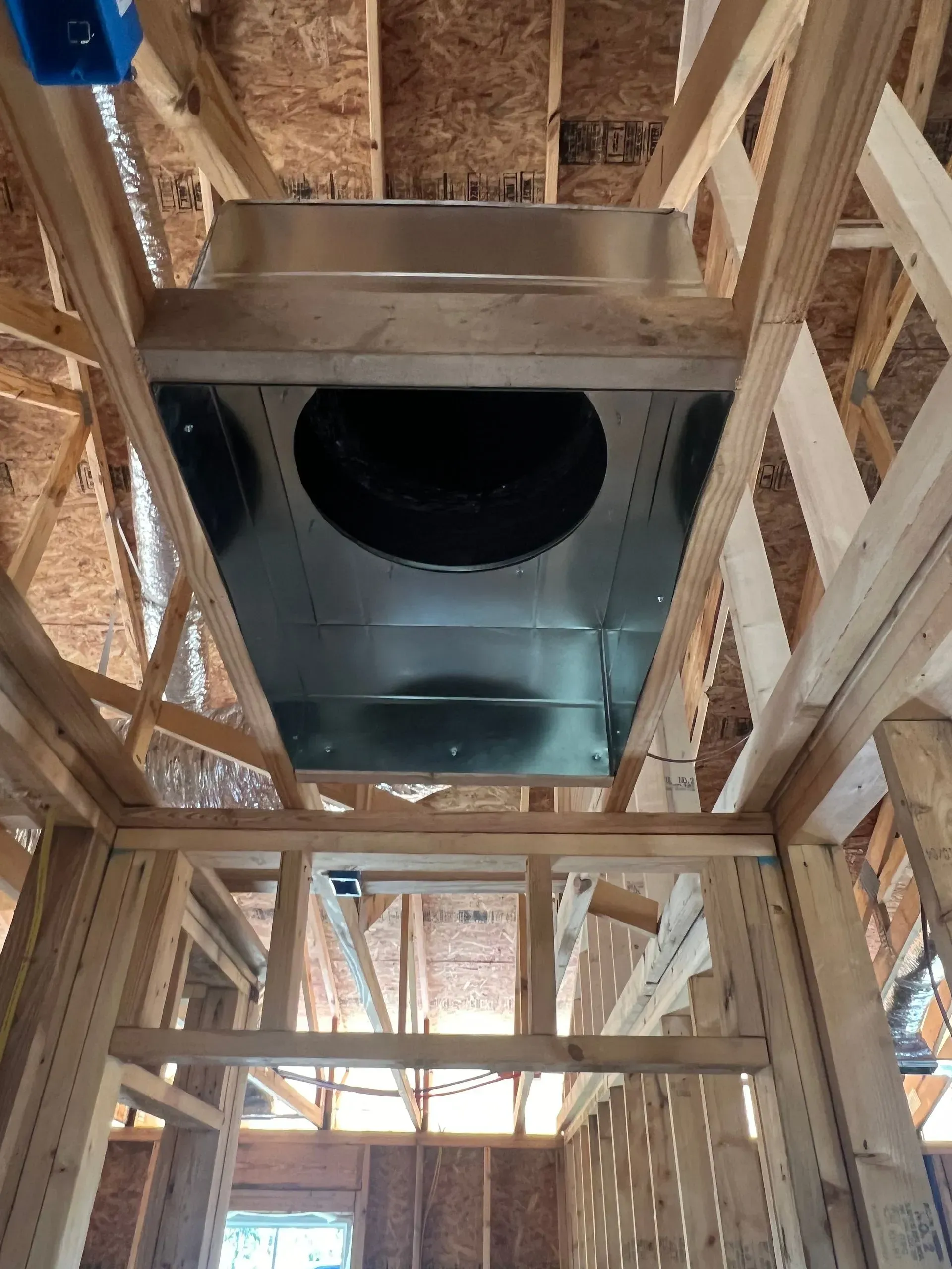 A ceiling fan is hanging from the ceiling of a building under construction.