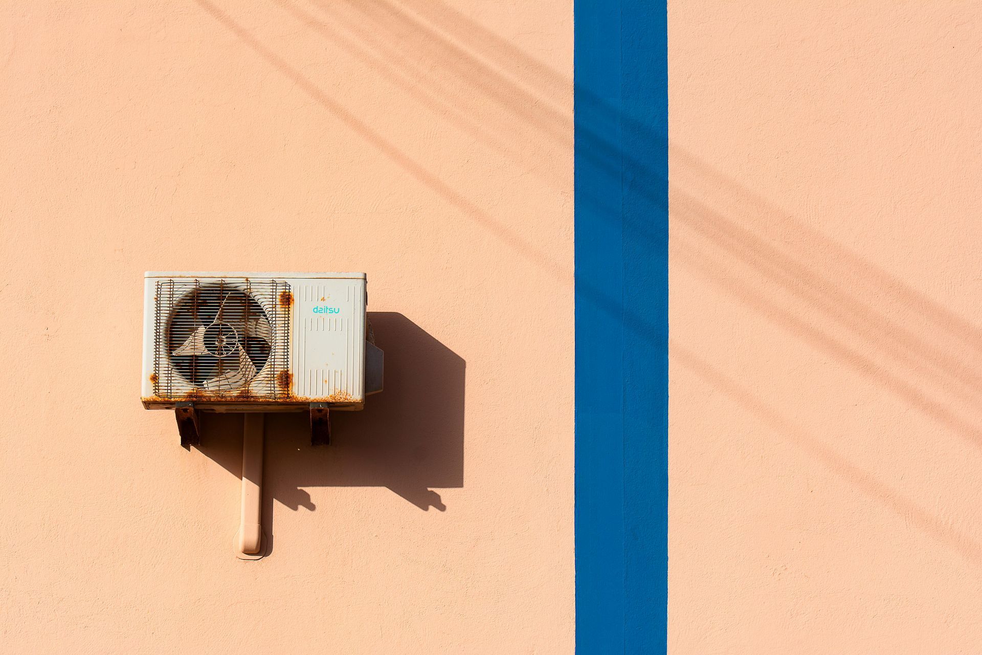 An air conditioner is mounted on the side of a building.