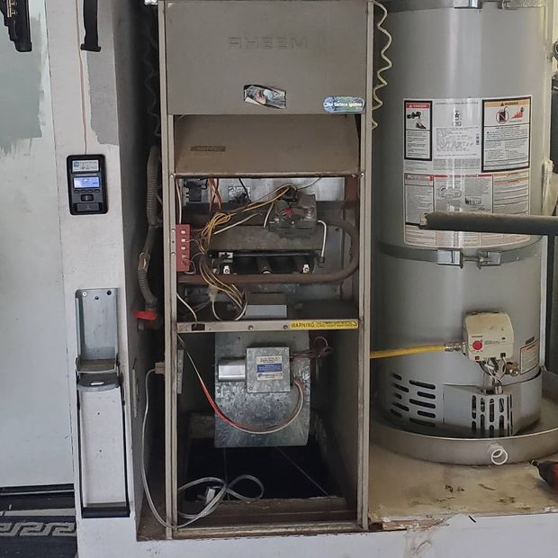 Blue gas flames on an industrial boiler in a metal utility room