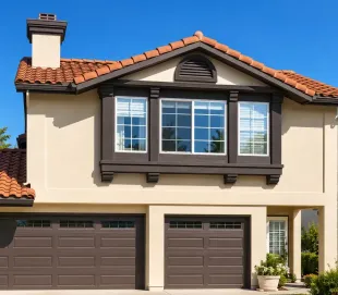 Two-story beige house with brown trim, tiled roof, and a three-car garage under a blue sky