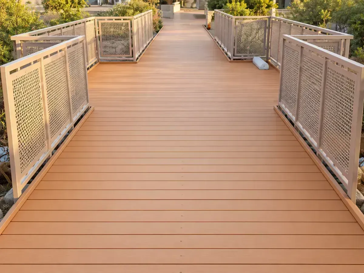 Wooden pedestrian bridge with ornate metal railings in a landscaped outdoor setting