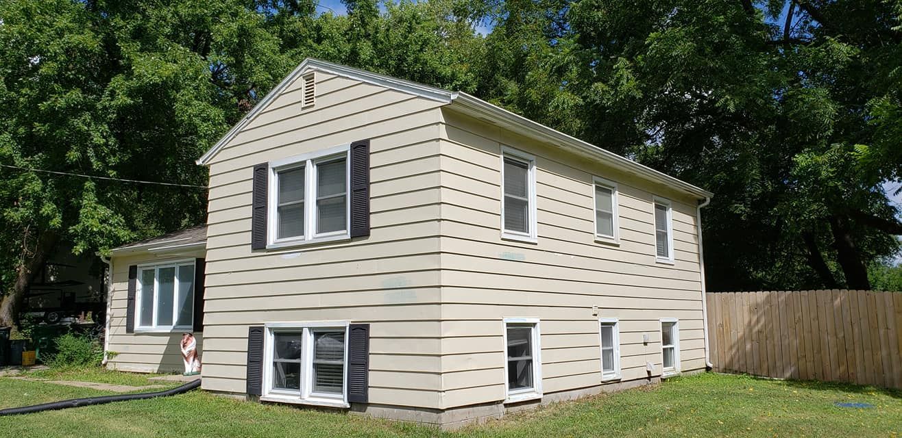 A house with a lot of windows and a fence in front of it