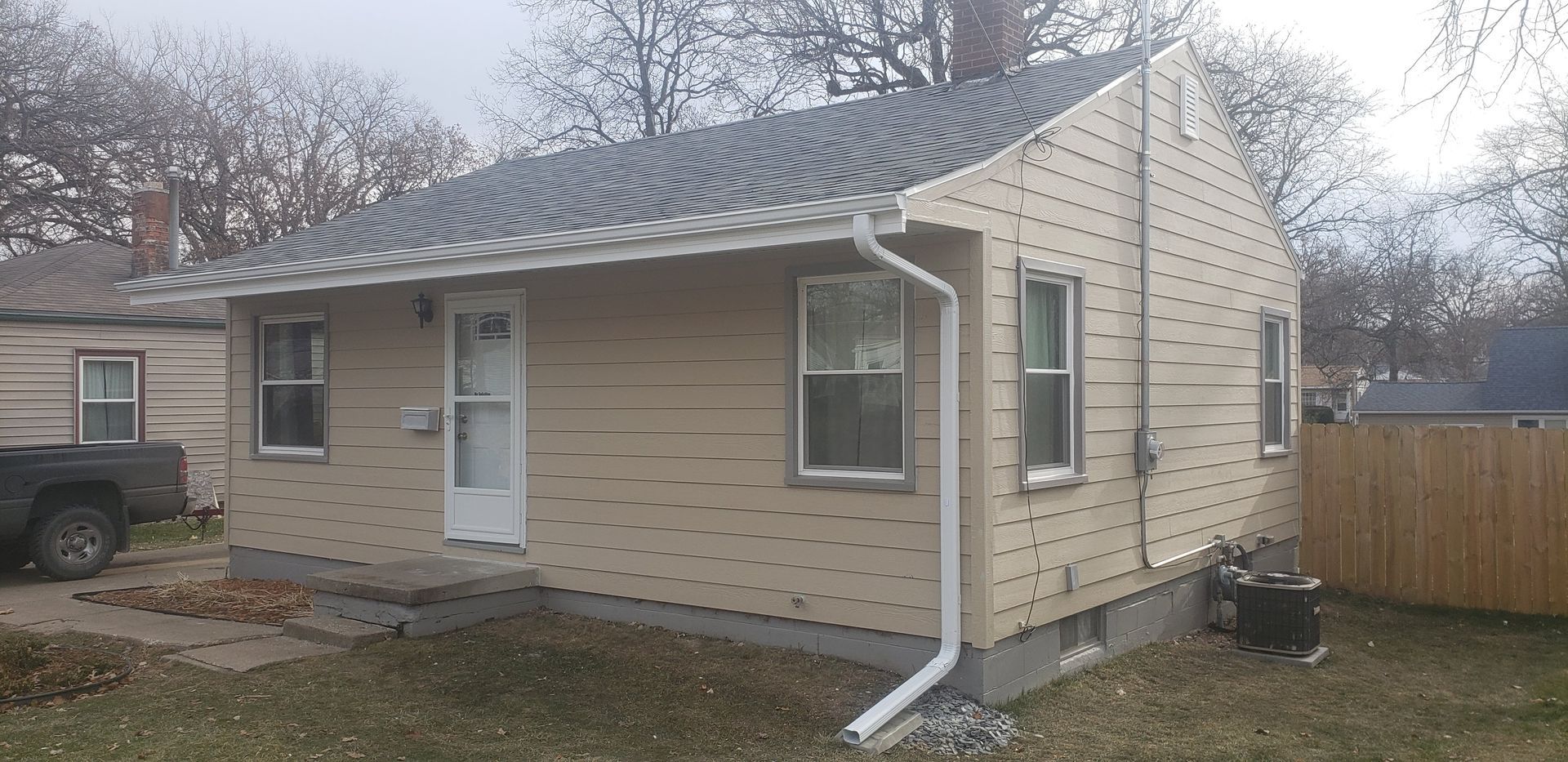 A small house with a truck parked in front of it