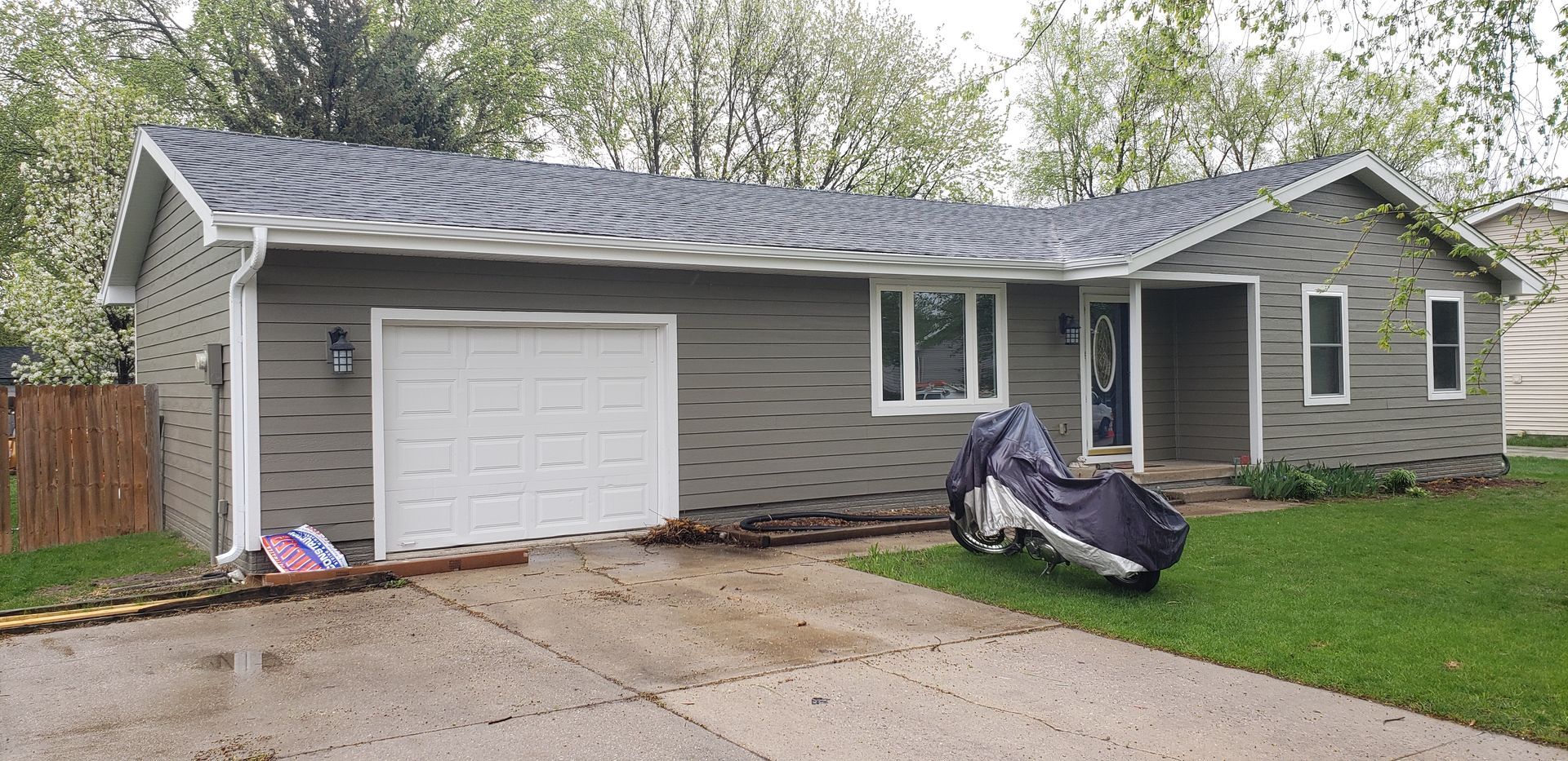 A house with a motorcycle parked in front of it
