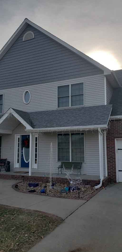 A large white house with a gray roof and a blue door