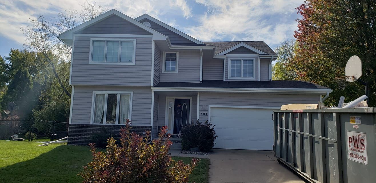 A large house with a dumpster in front of it