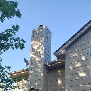A house with a chimney and a satellite dish on the roof