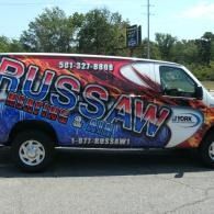 RUSSAW Plumbing van with red, blue, and white graphics parked outdoors