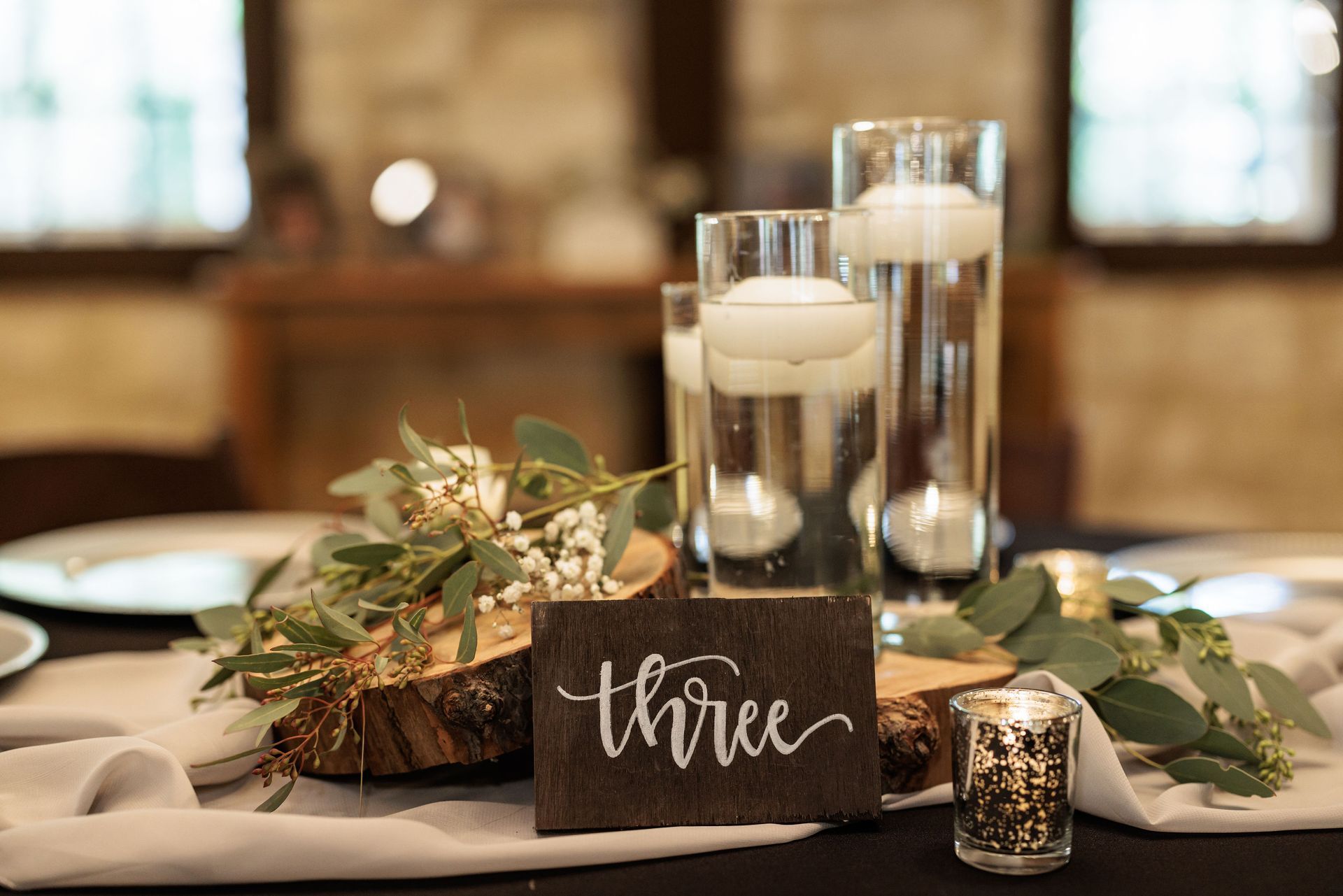 A table with a wooden sign that says three on it.
