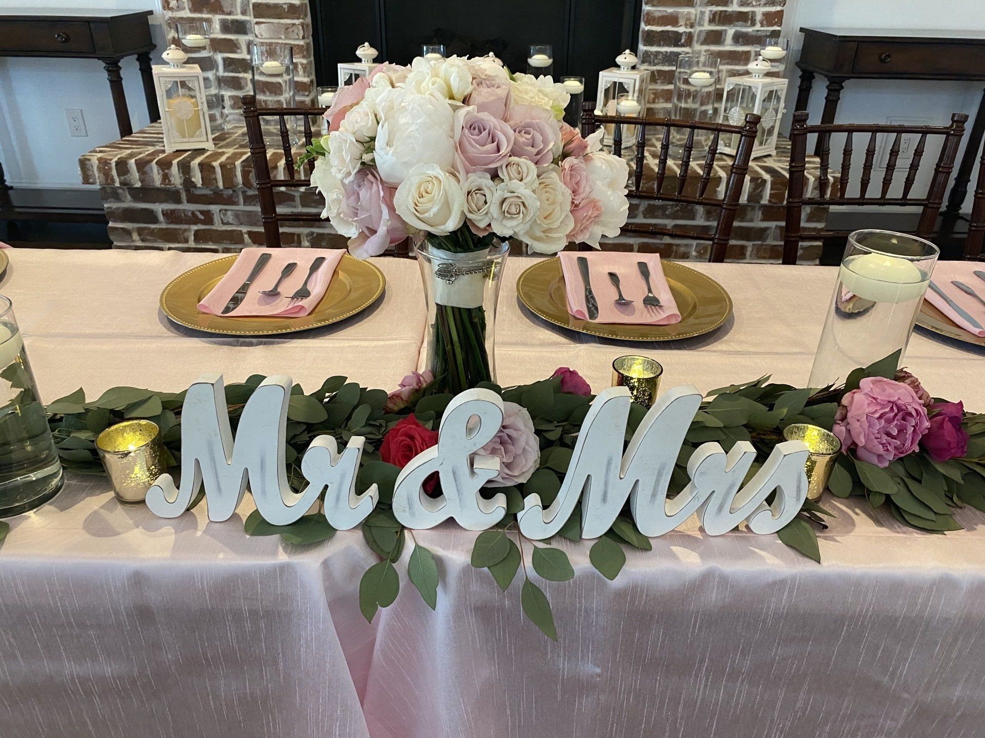 A table with a bouquet of flowers and a sign that says mr. and mrs.