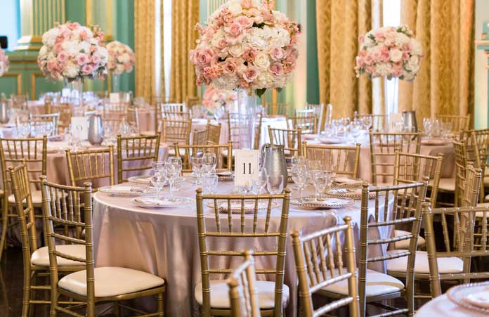 A large room with tables and chairs set up for a wedding reception.