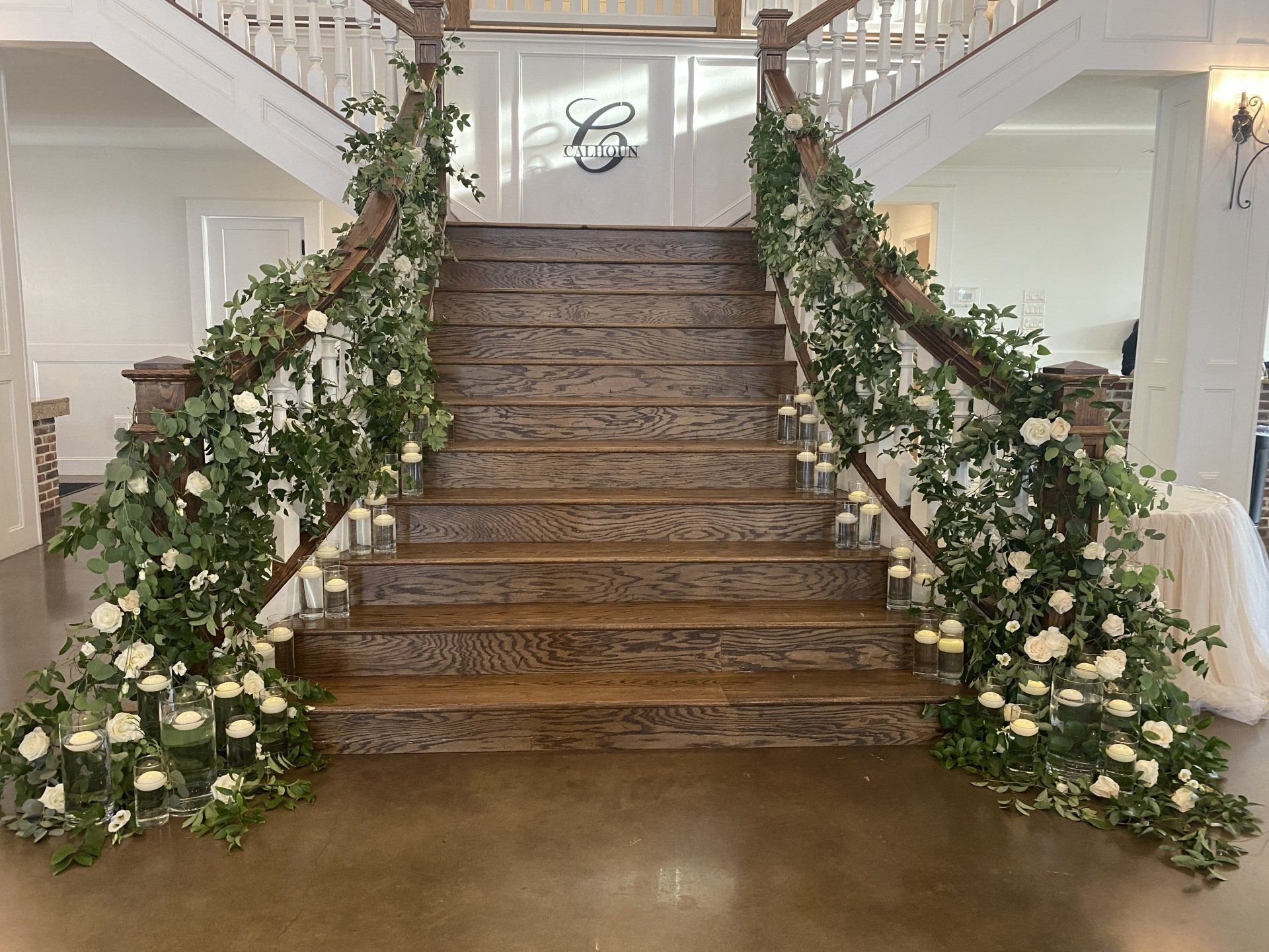 A wooden staircase decorated with flowers and candles.