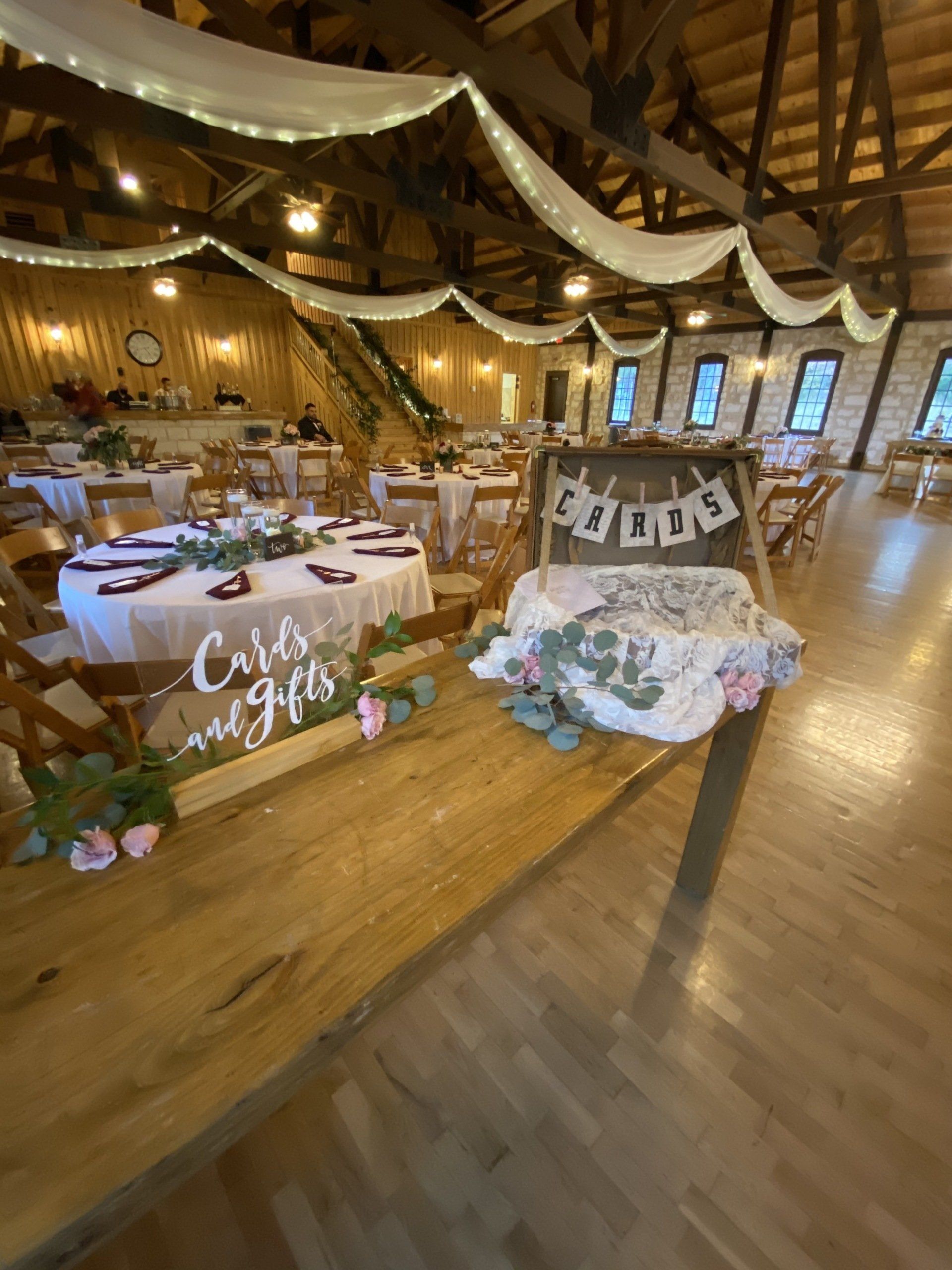 A large room with tables and chairs set up for a wedding reception.