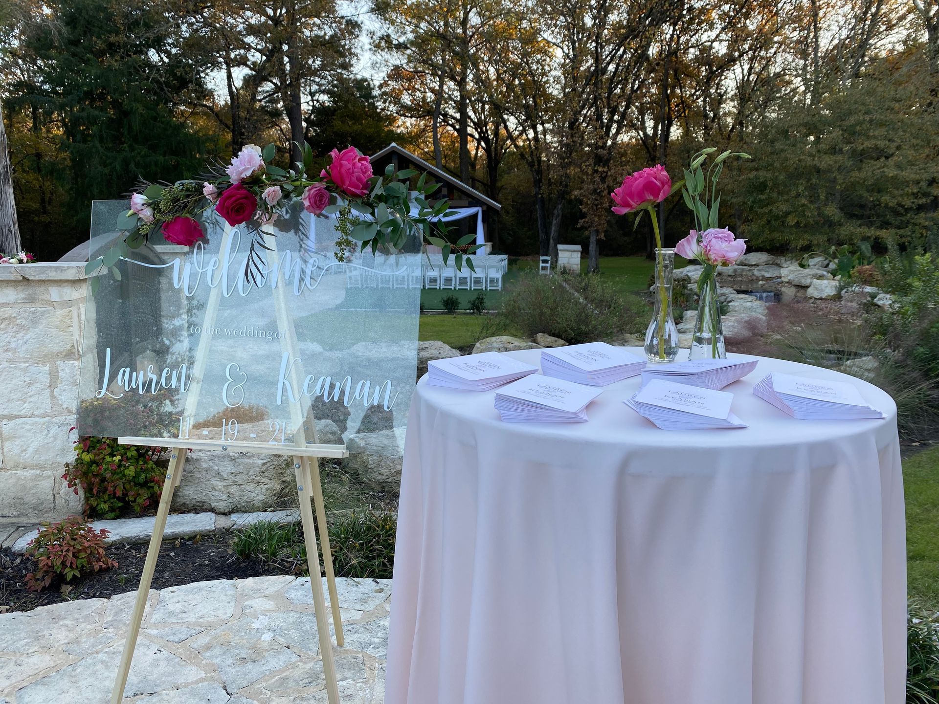 A table with a sign on it and flowers on it.