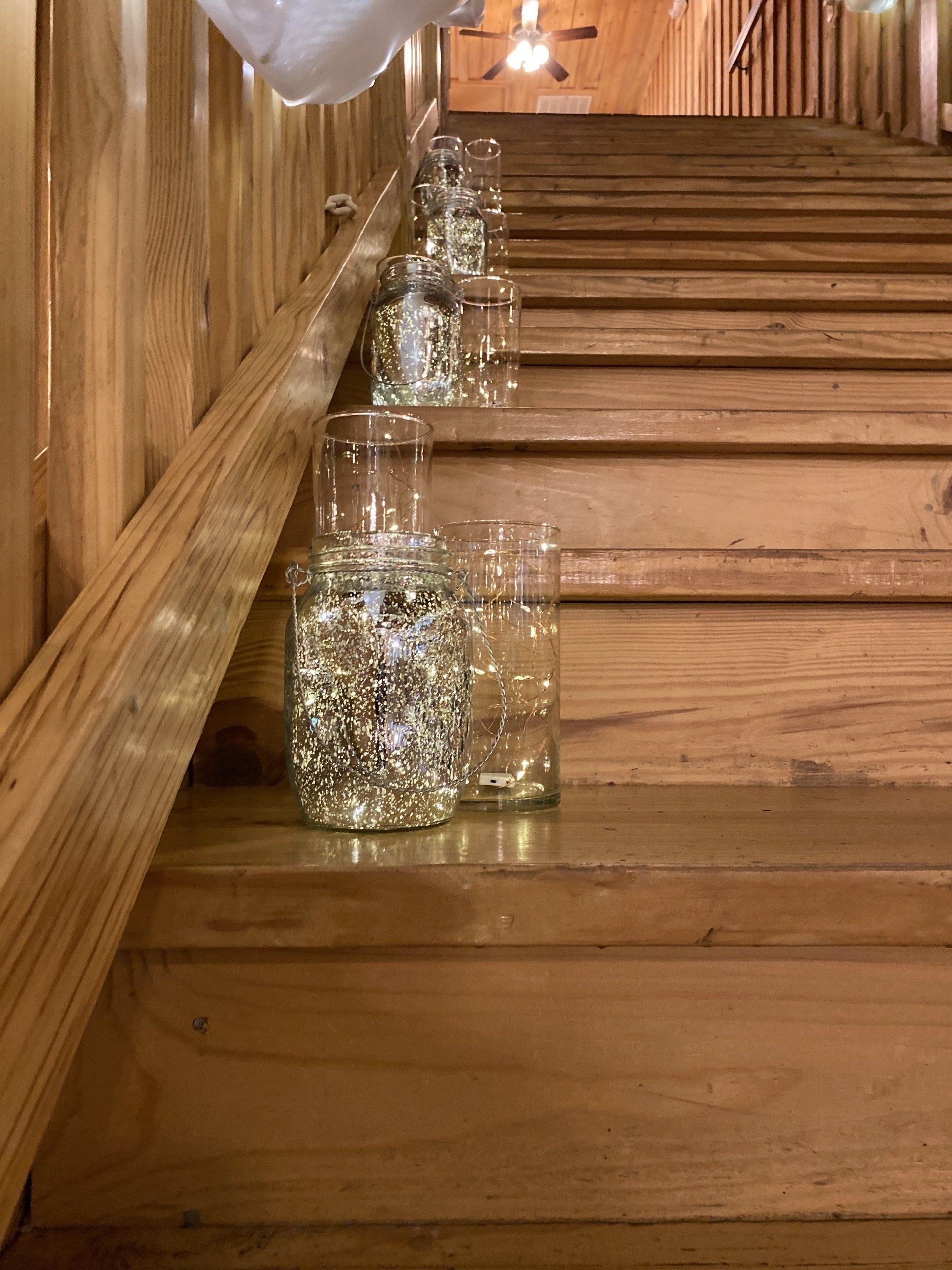 A row of wooden stairs with glasses filled with rhinestones on the steps.