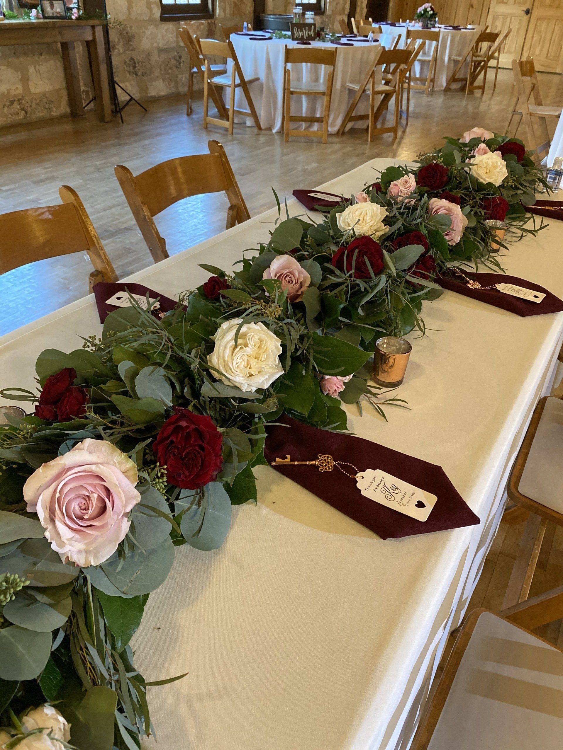A long table with flowers and a name tag on it.