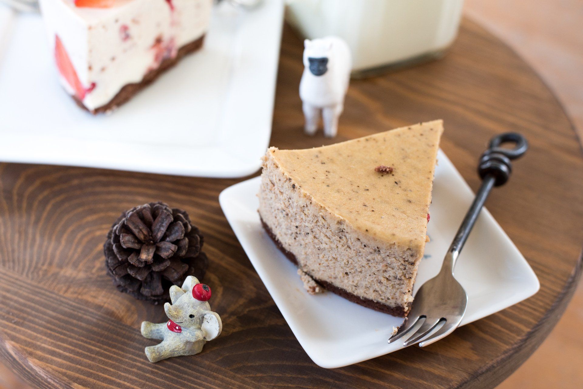 A slice of cheesecake on a white plate with a fork