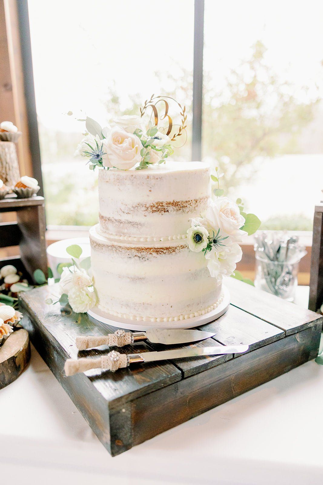 A wedding cake is sitting on top of a wooden tray on a table.