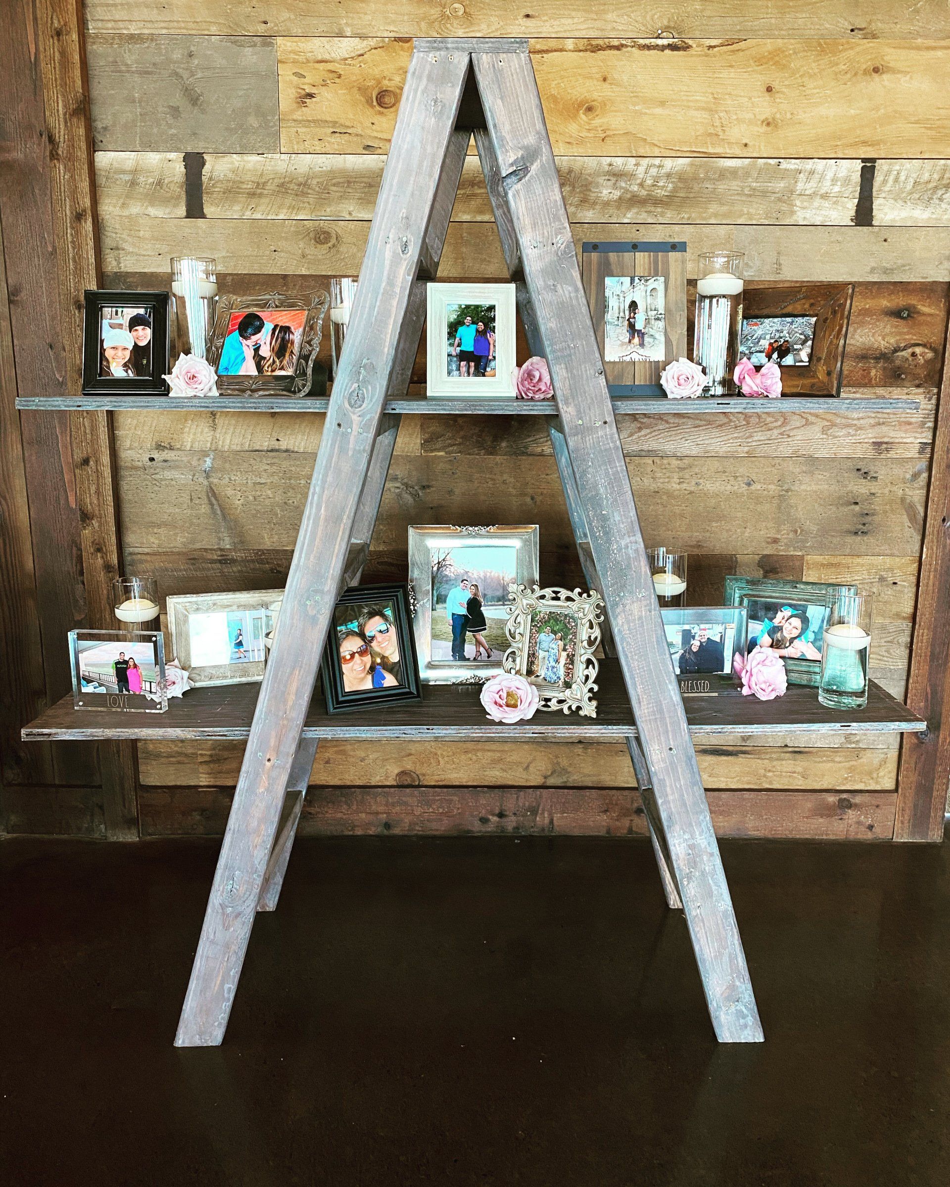 A wooden ladder filled with pictures and candles.