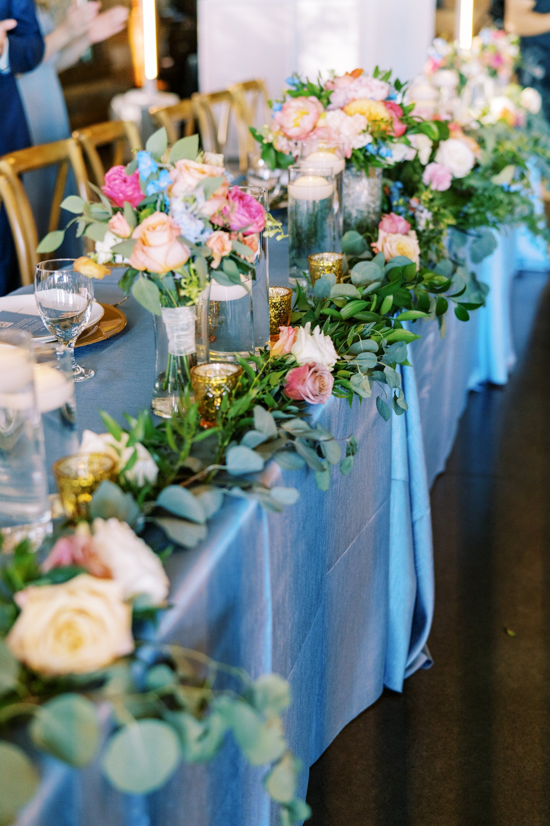A long table decorated with flowers and candles for a wedding reception.