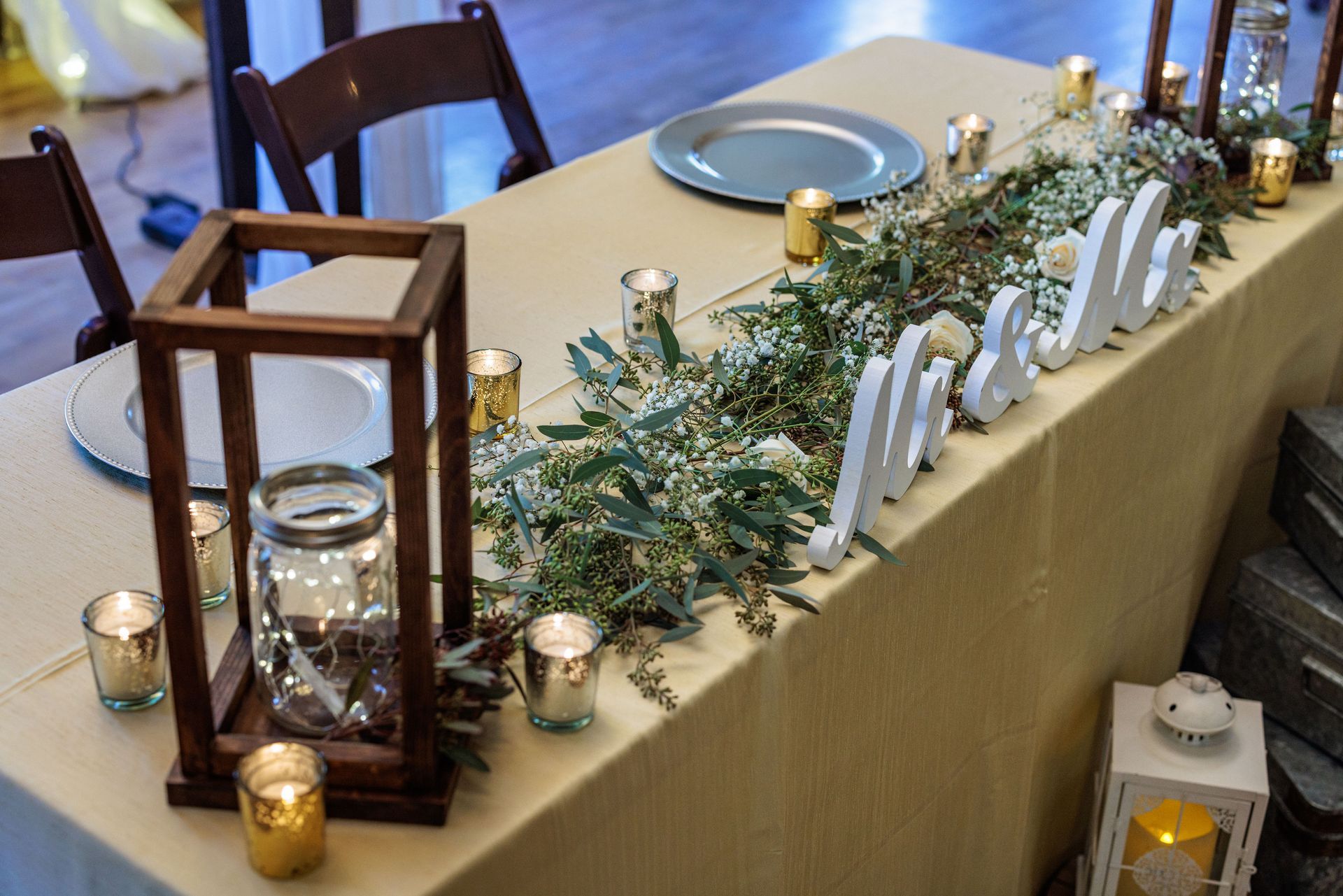 A long table with candles and a sign that says mr. and mrs.