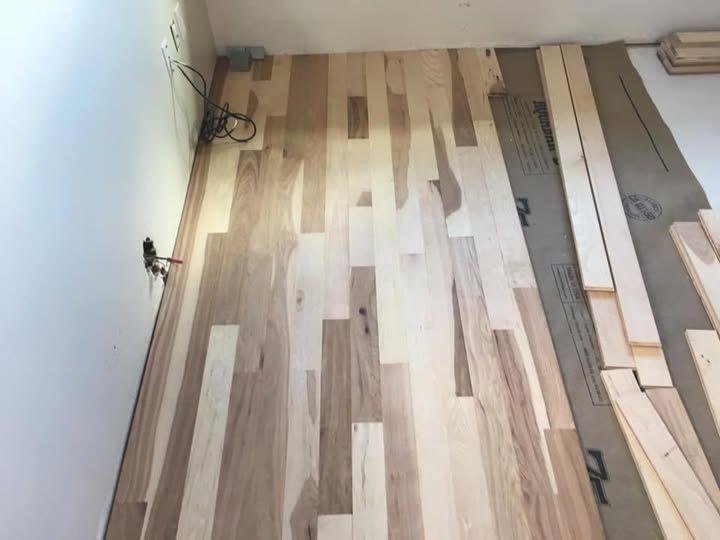 A wooden floor is being installed in a room.