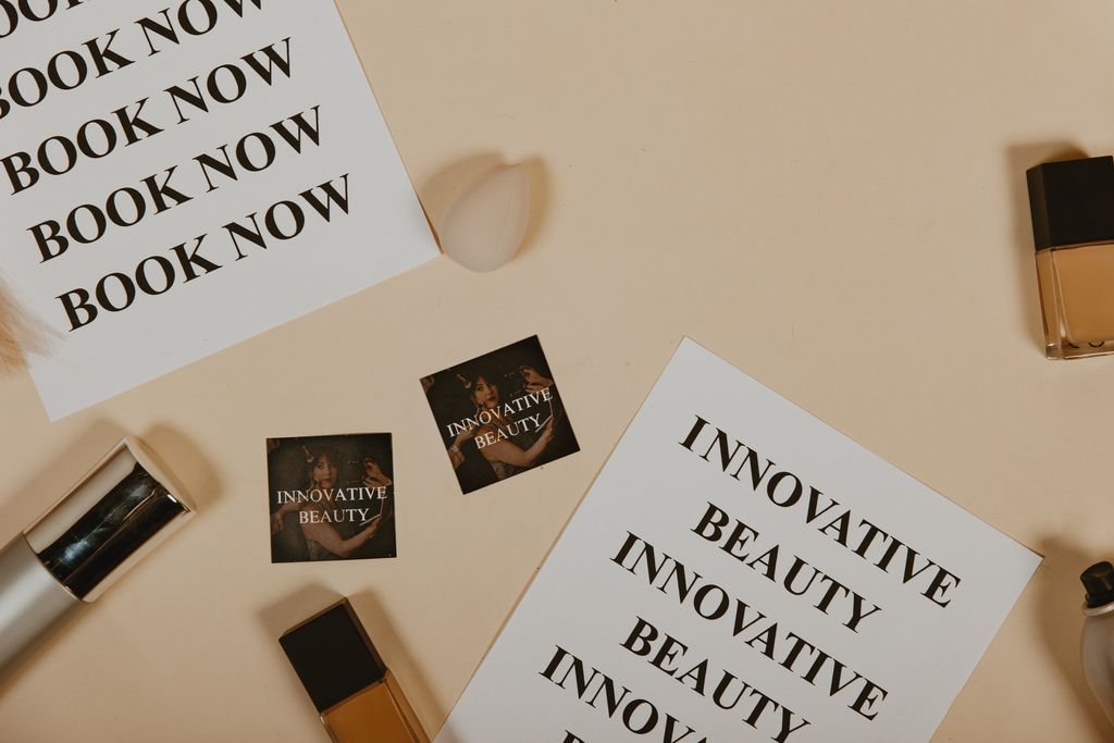 Beauty brand flat lay with “BOOK NOW” and “INNOVATIVE BEAUTY” cards, skincare items on beige background