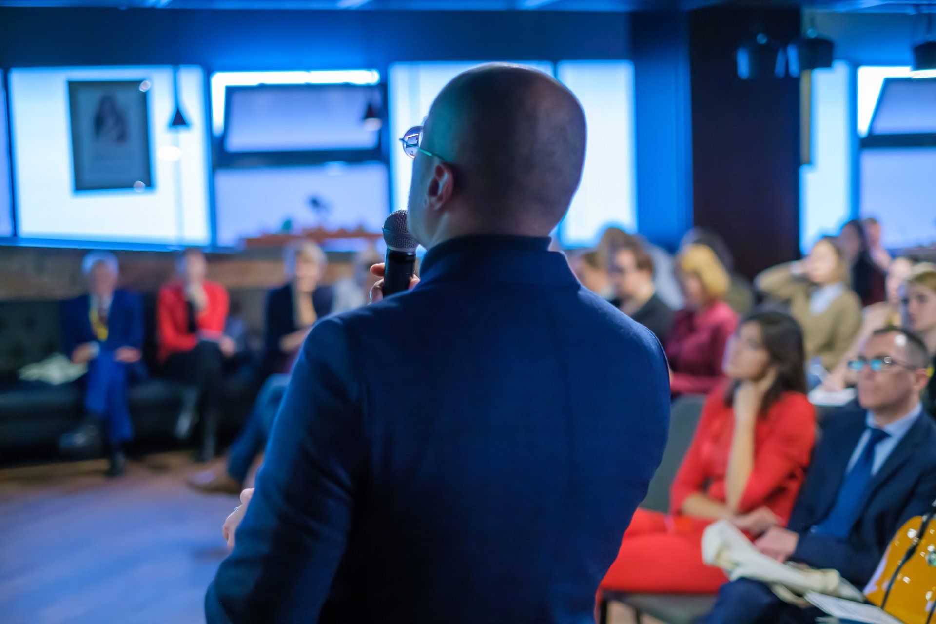 Male presenter speaks to audience at seminar