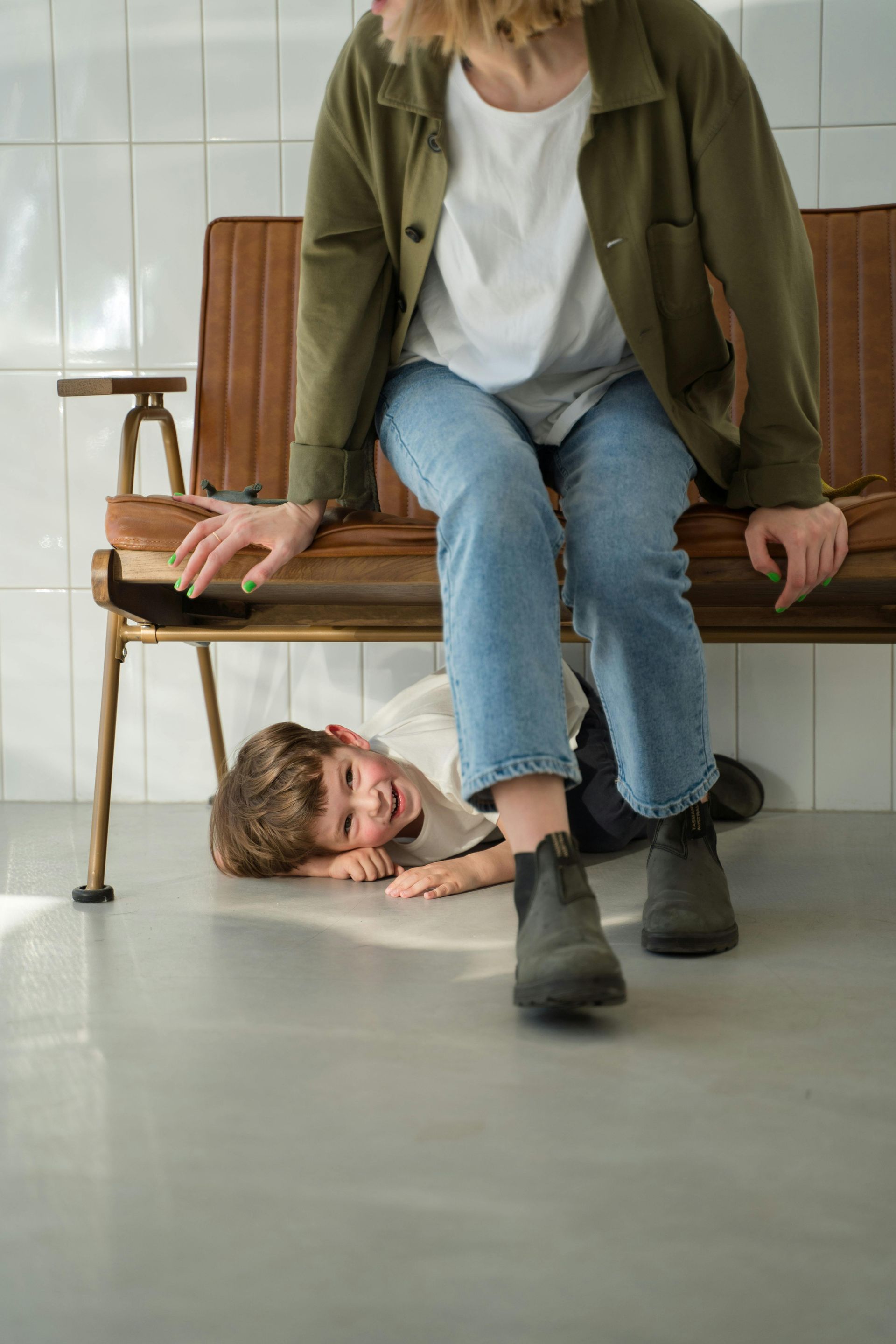 A man and a woman are sitting on the floor in a gym . the woman is bandaging the man 's ankle.