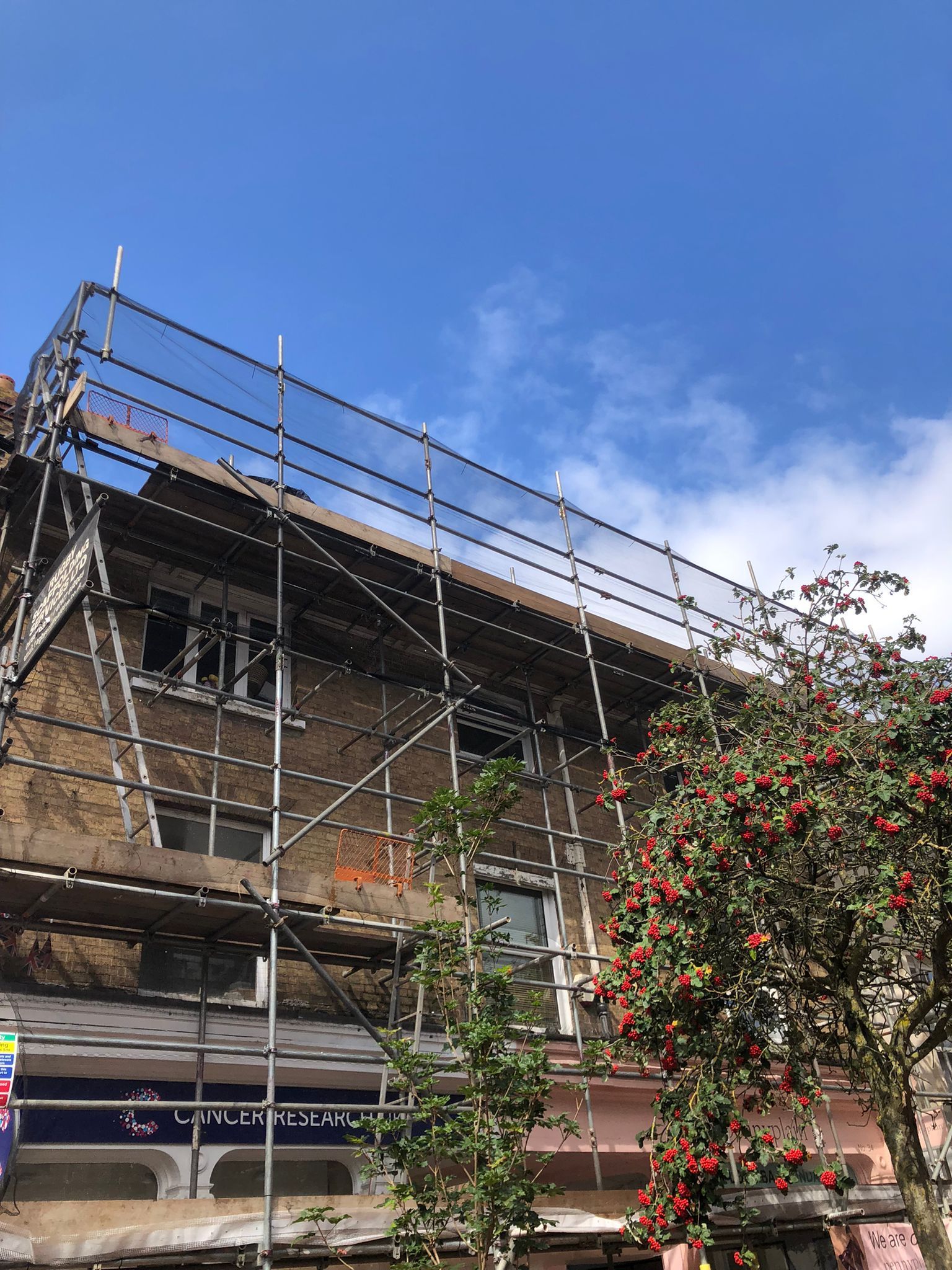 This is a photo of some flats with a scaffolding tower up. this was done by Leicester Scaffolding Services JK