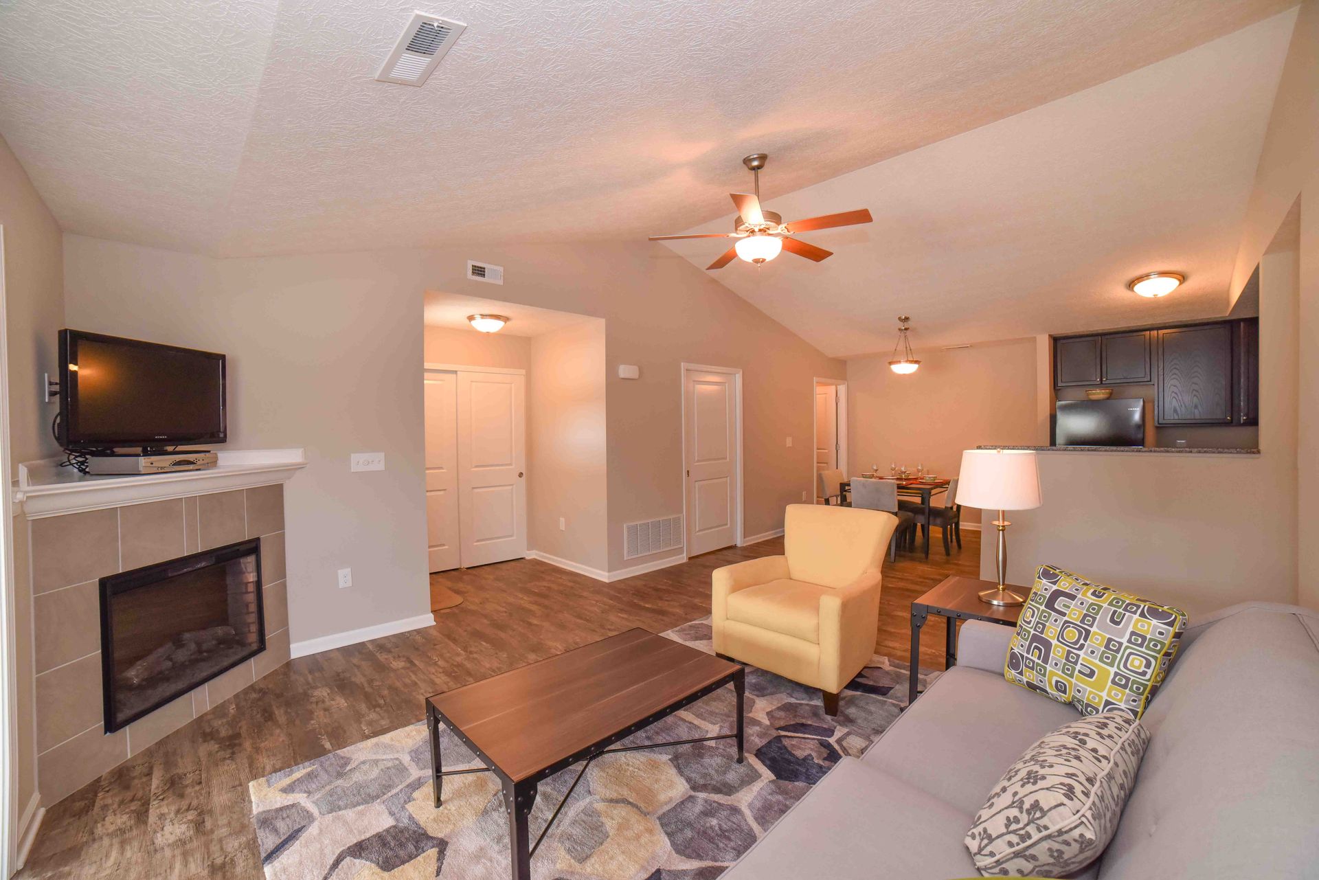 A living room with a couch , chair , coffee table and fireplace.