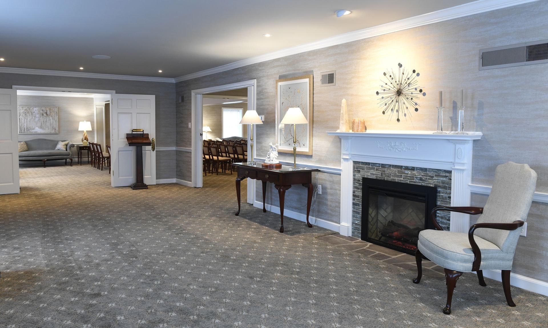 Indoor corner fireplace with stacked stone surround and wooden mantel.