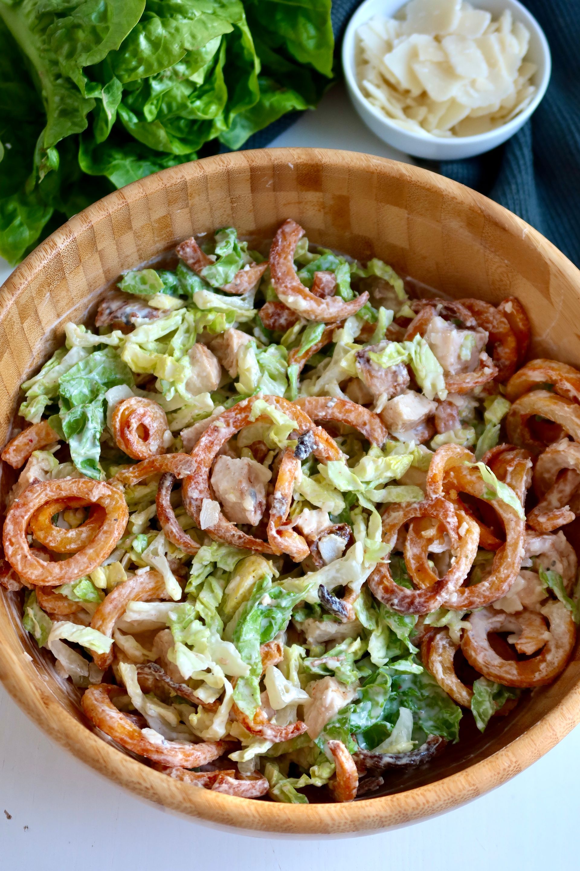 Knusprige Curly Fries im Caesar Salat