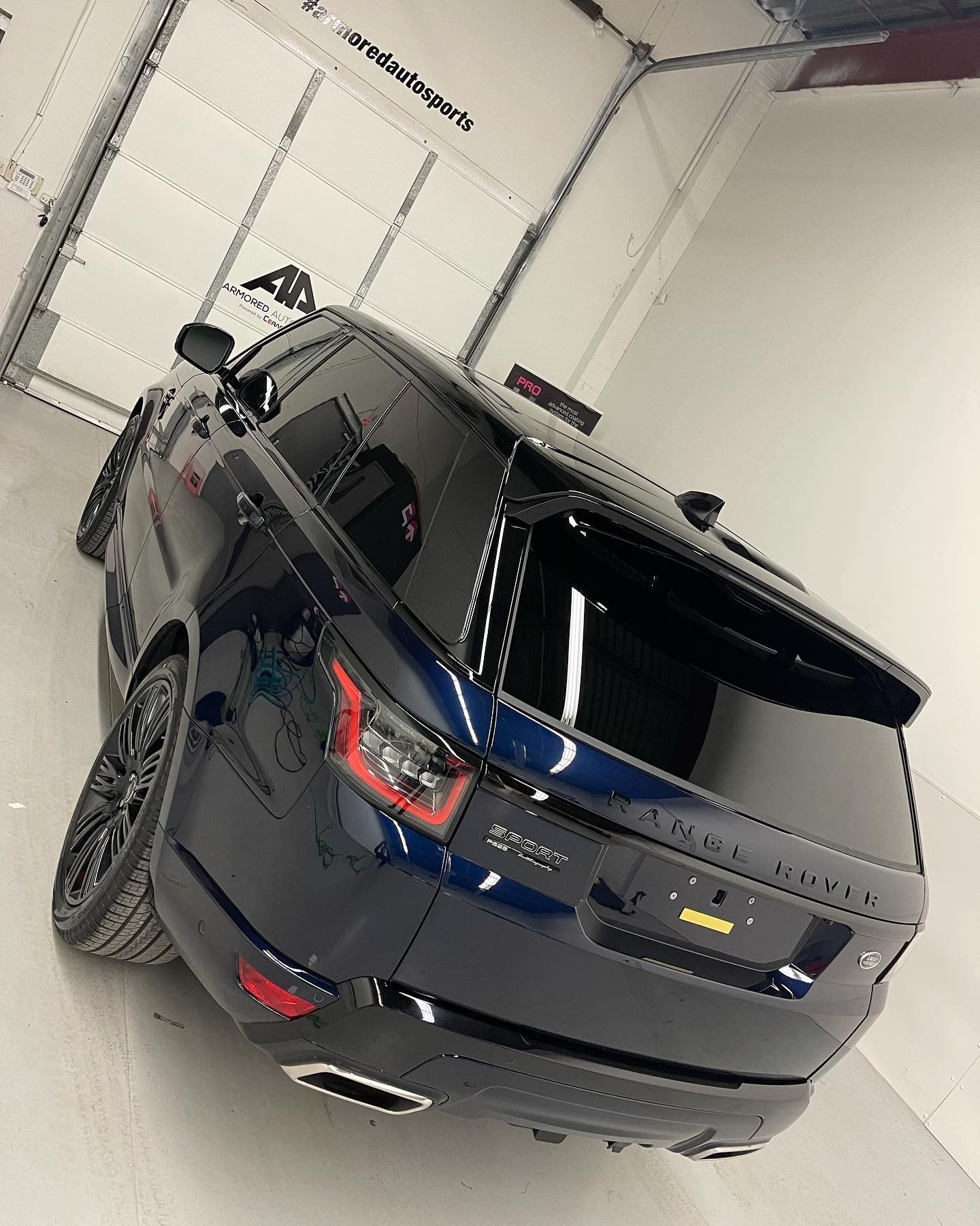 A dark blue Range Rover Sport parked in a bright, modern garage.