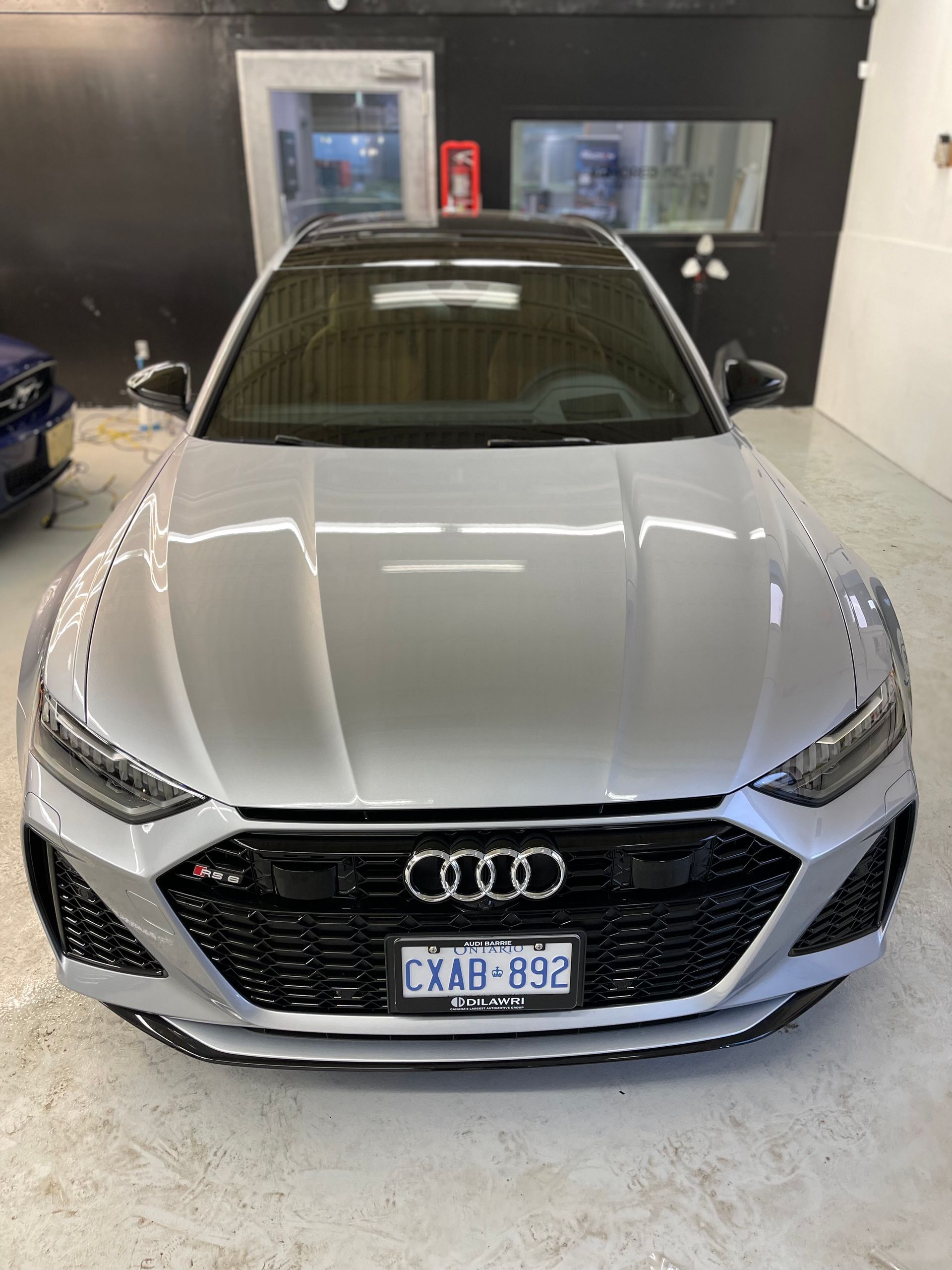 A silver Audi RS 6 station wagon parked indoors, facing forward with a dark grille and license plate visible.