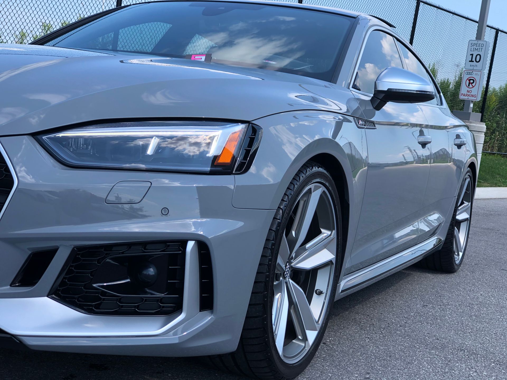 A gray Audi sedan parked outdoors, capturing the front quarter view, wheels, and aerodynamic styling.